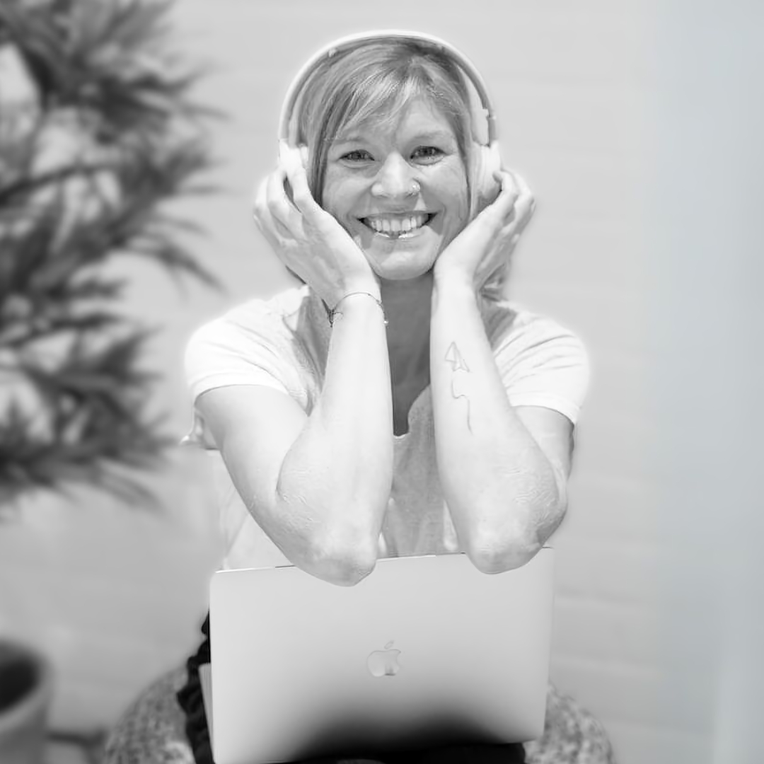 sunshine podcast starthilfe youtube service Sunshine VA mit weißen Kopfhörern, die sie sich rechts und links festhält. Sitzt auf einem Korb-Puff und lehnt sich an ihrem Laptop an